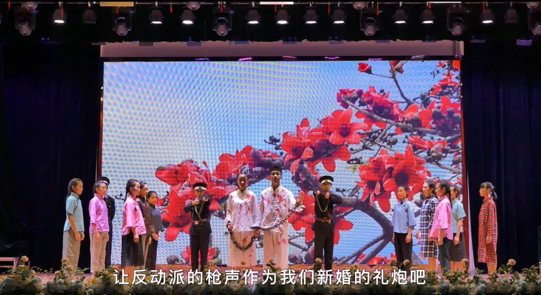 12  5月21日，為慶祝建黨100周年，開(kāi)平市金山中學(xué)共青團(tuán)員、少先隊(duì)員在體育館上演舞臺(tái)劇《烈骨忠魂木棉情》，謳歌僑鄉(xiāng)英雄周文雍和陳鐵軍的革命故事。1.png