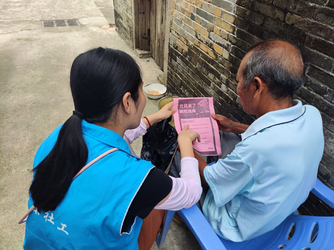 “雙百”社工為老人制作防風(fēng)避險(xiǎn)指南，并解說防御臺風(fēng)知識.png